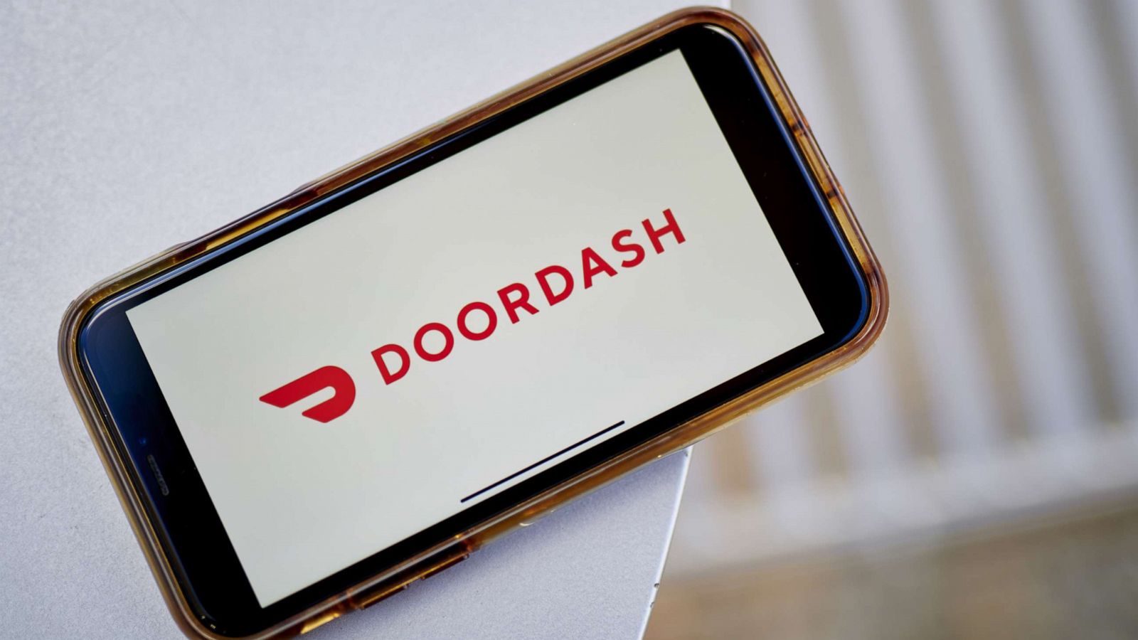 PHOTO: In this Dec. 1, 2020, file photo, the logo for DoorDash is shown on a smartphone.