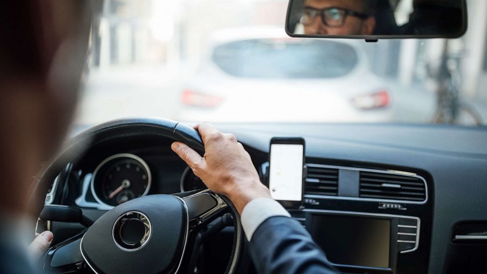 A man dressed in a business suit drives a car in an undated stock photo.