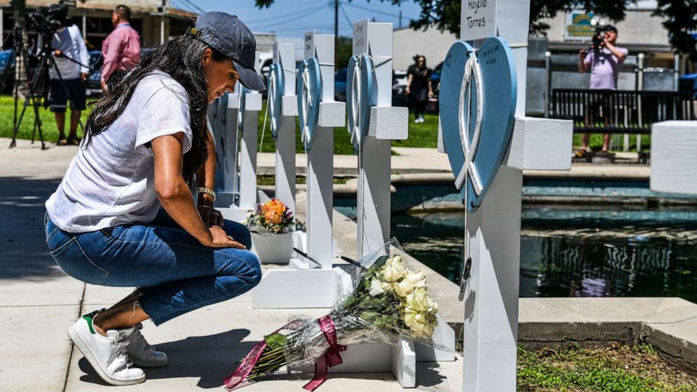 PHOTO: Meghan, Duchess of Sussex, places flowers as she mourns at a makeshift memorial outside Uvalde County Courthouse in Uvalde, Texas, May 26, 2022. 