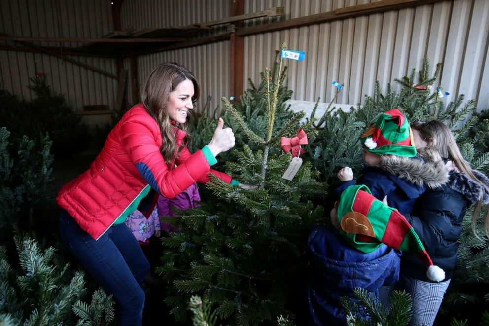 PHOTO: Britain's Catherine, Duchess of Cambridge moves a Christmas tree during a visit to Peterley Manor Farm where she took part in activities with families who are supported by the Family Action charity, in Buckinghamshire, England, Dec. 4, 2019.