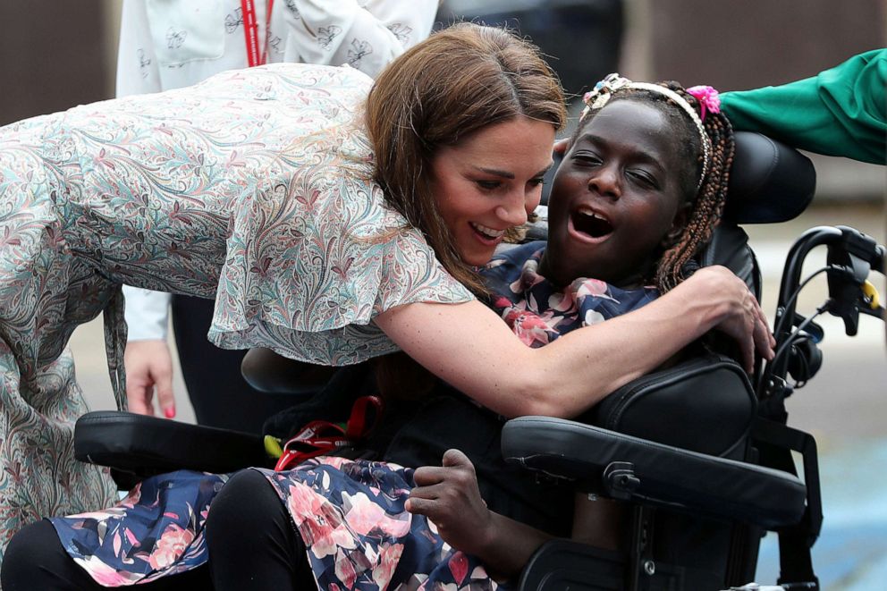 PHOTO: Britain's Kate, Duchess of Cambridge hugs Faith Olukoya at a photography workshop for Action for Children, run by the Royal Photographic Society in Kingston, England, June 25, 2019.