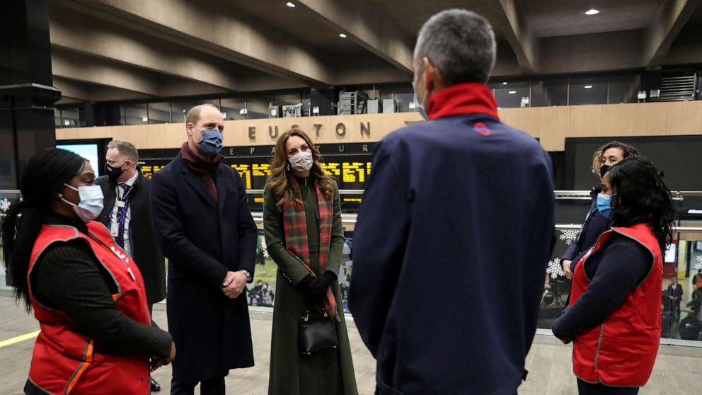 PHOTO: Britain's Prince William and Catherine, Duchess of Cambridge, speak to transport workers at London Euston Station