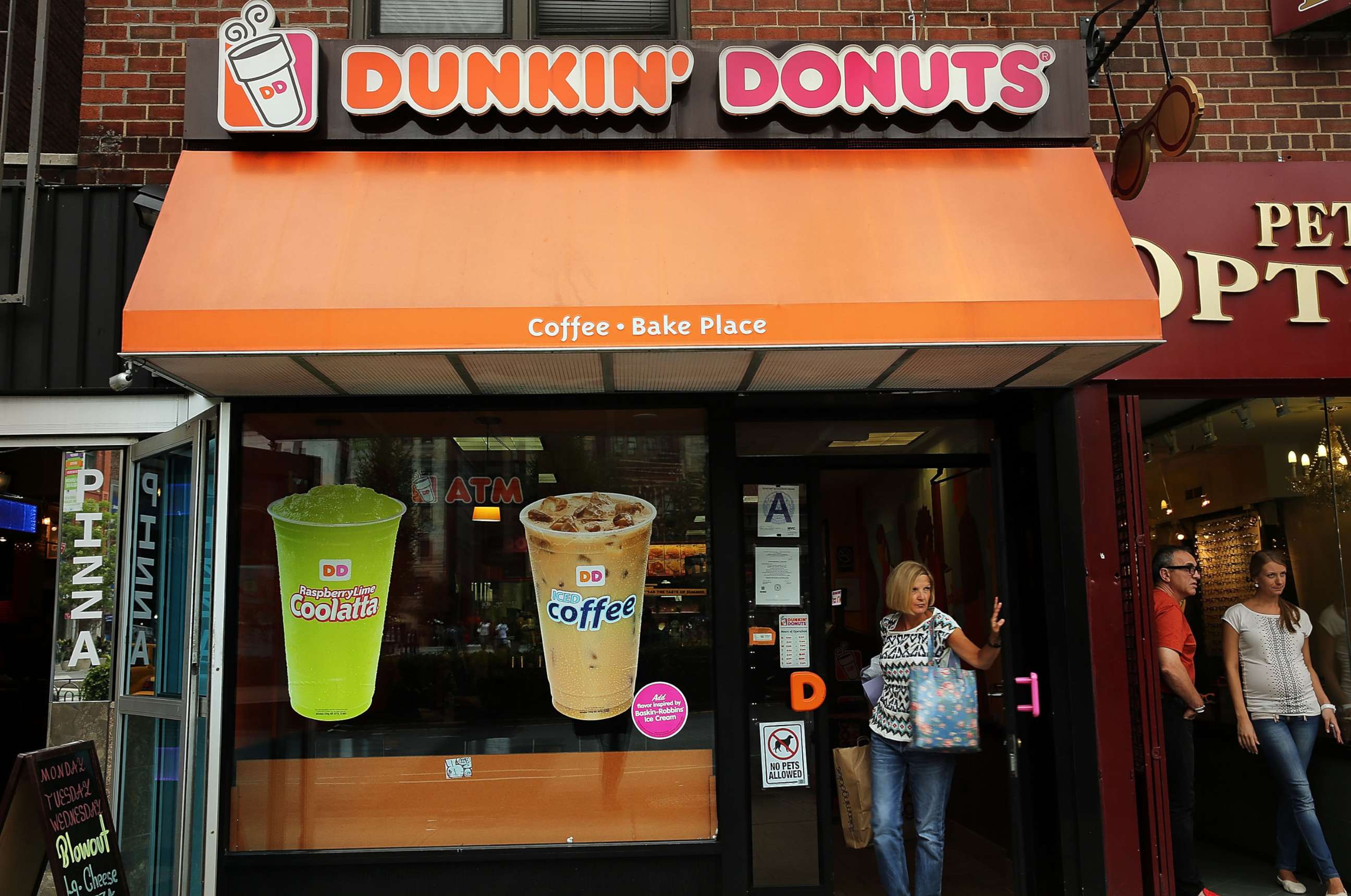 PHOTO: A woman walks out of a Dunkin' Donuts in New York City.