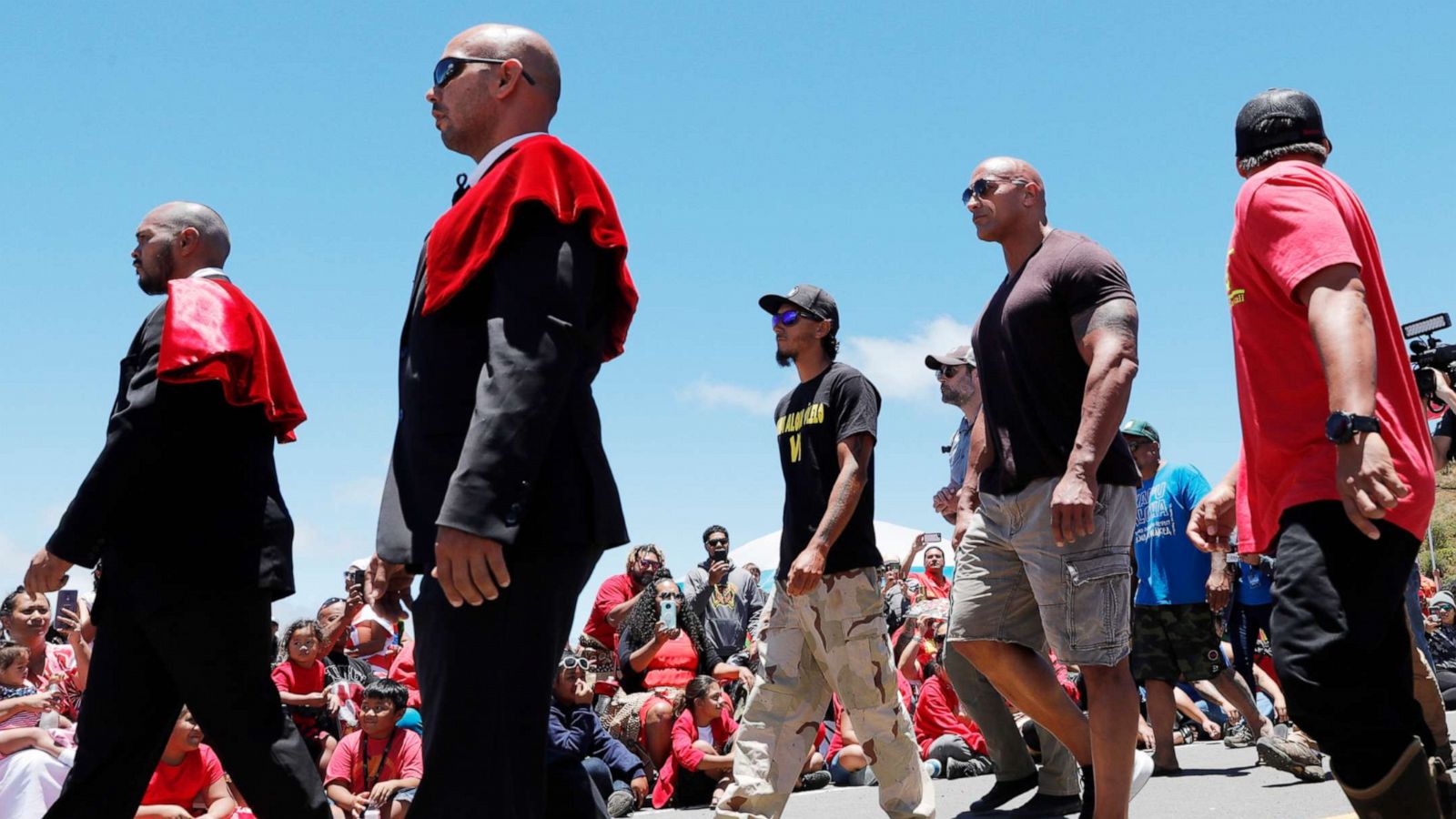 PHOTO: Dwayne "The Rock" Johnson, third from right, walks with TMT opposition leader Kaho'okahi Kanuha accompanied by the Royal Order of Kamehameha I during a protest against the TMT telescope on July 24, 2019, at the base of Mauna Kea on Hawaii Island.