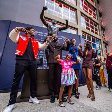 PHOTO: Dwyane Wade and his family strike the pose depicted in the statue after it was unveiled in front of Kaseya Center, Oct. 27, 2024, in Miami. 