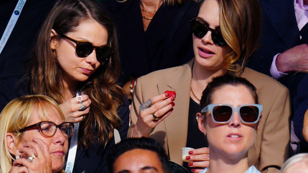 PHOTO: Cara Delevingne and girlfriend Minke eat strawberries and cream in the stands at the Wimbledon Tennis Championships, July 10, 2023, in London.