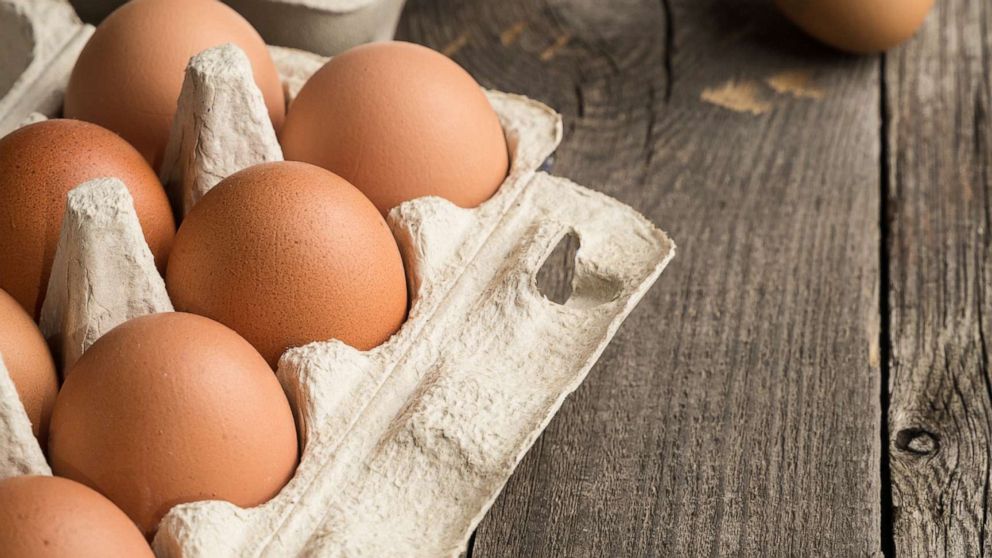 PHOTO: Eggs are seen in box container on a wooden table in this stock photo.