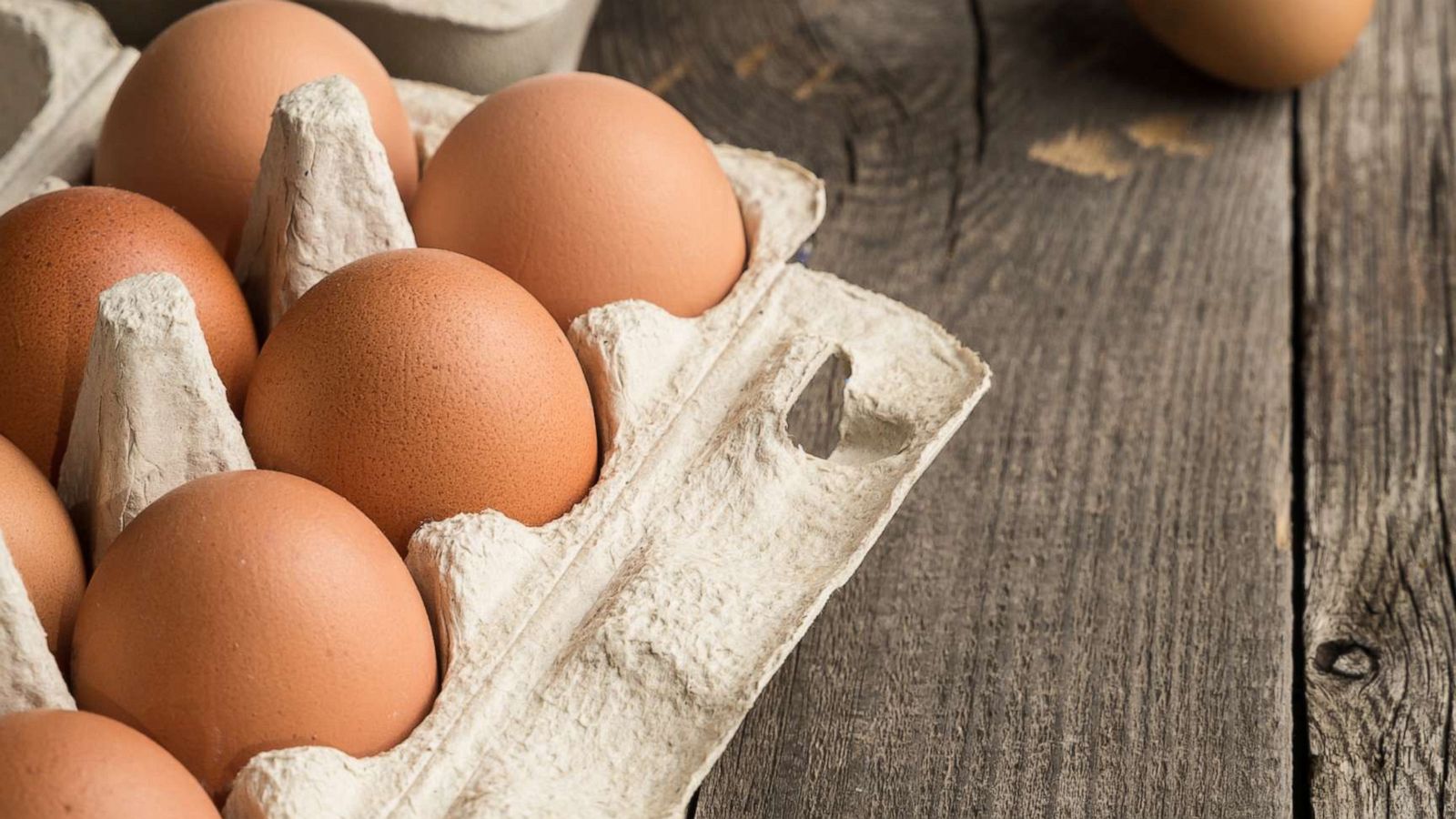 PHOTO: Eggs are seen in box container on a wooden table in this stock photo.