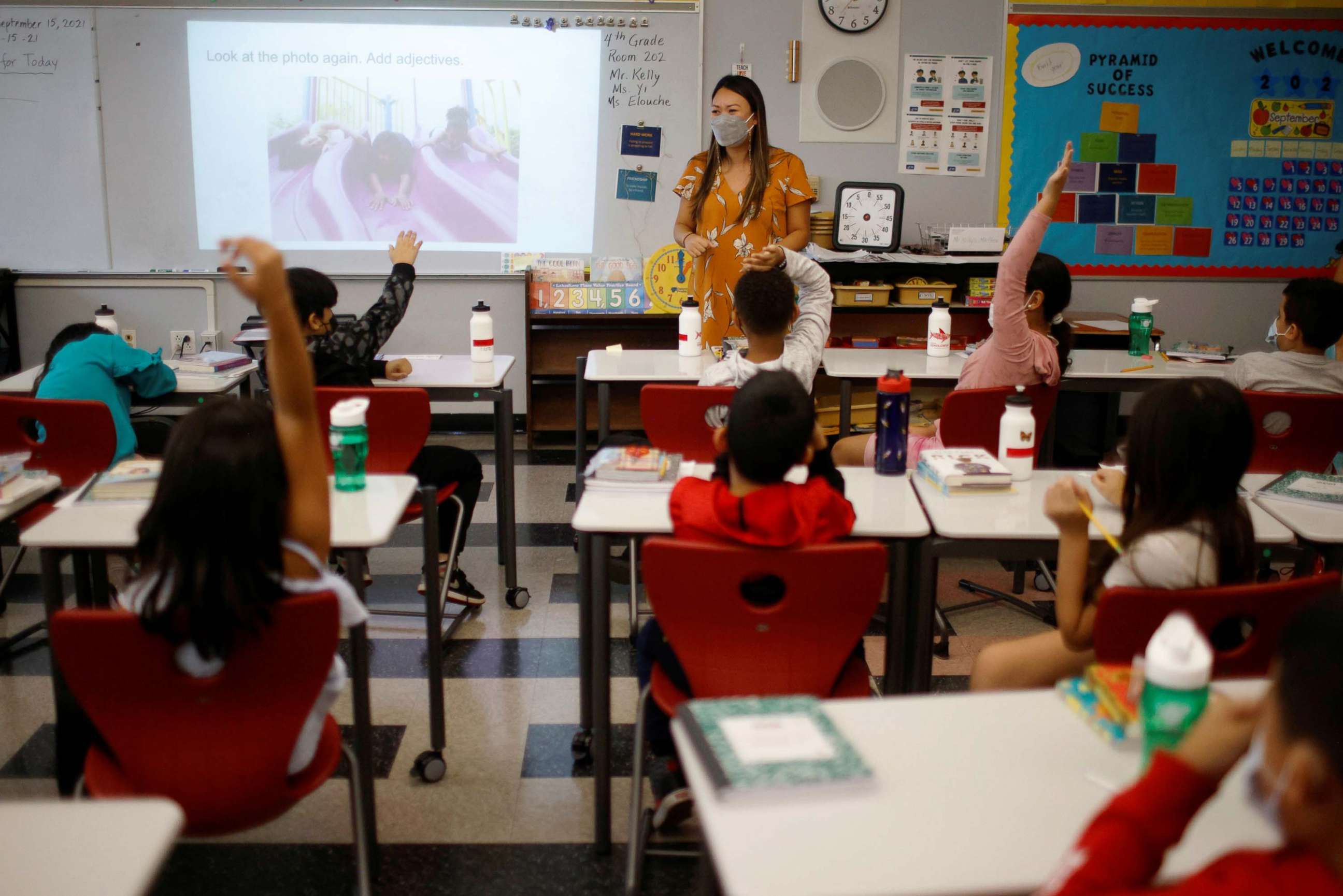 PHOTO: Teacher Mary Yi works with fourth grade students at the Sokolowski School, where students and teachers are required to wear masks because of the COVID-19 pandemic, in Chelsea, Mass., Sept. 15, 2021.