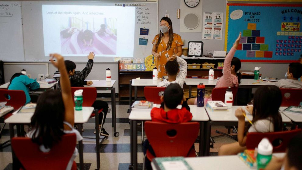 PHOTO: Teacher Mary Yi works with fourth grade students at the Sokolowski School, where students and teachers are required to wear masks because of the COVID-19 pandemic, in Chelsea, Mass., Sept. 15, 2021.