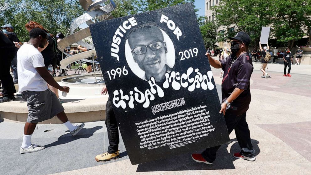 PHOTO: Demonstrators carry a giant placard during a rally and march over the death of Elijah McClain outside the police department in Aurora, Colo., June 27, 2020.
