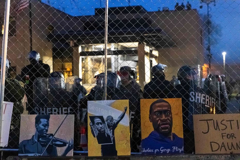 PHOTO: Elijah McClain and George Floyd pictures left behind by demonstrators line the fence outside the Brooklyn Center police station during a protest after the death of Daunte Wright, in Brooklyn Center, Minn., April 14, 2021.