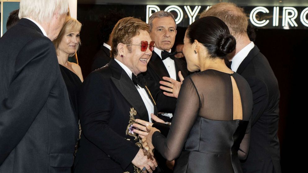 PHOTO: Britain's Prince Harry, Duke of Sussex (R) and Britain's Meghan, Duchess of Sussex (2nd R) chat with British singer-songwriter Elton John (C) as they arrive to attend the premiere European film The Lion King in London on July 14, 2019.