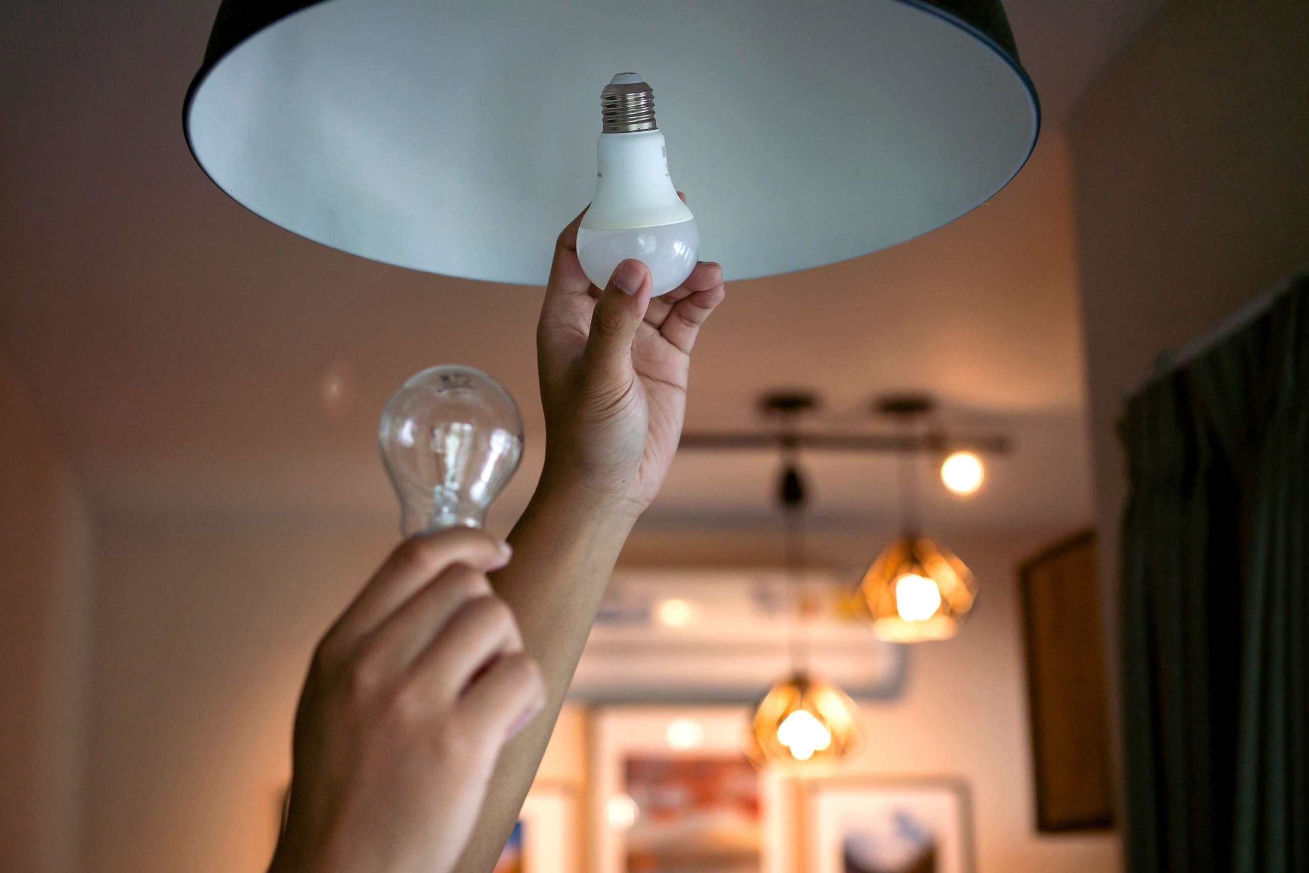 PHOTO: Replacing an incandescent light bulb with an energy efficient LED bulb.