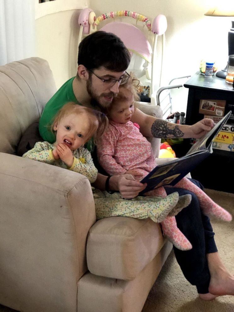 PHOTO: Twins Erin and Abby Delaney are seen an undated photo listening to a story read by their father, Riley Delaney.