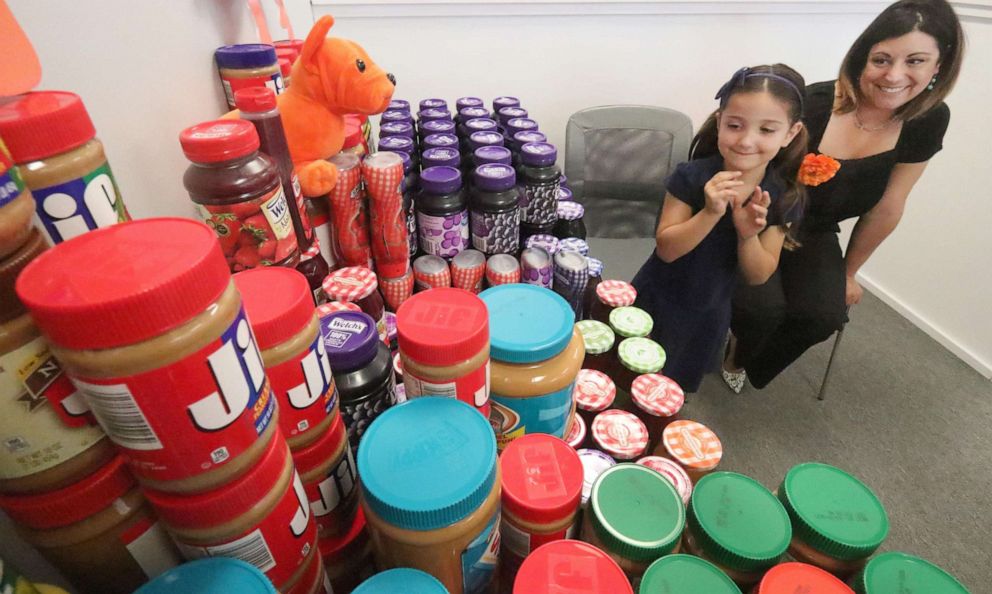 PHOTO: Eva Chapman, a six year old Spruce Creek Elementary kindergartener and her mom Nicole Chapman look at the hundred or more jars of peanut butter and jelly Eva collected for a food drive, May 13, 2019 so kids won’t go hungry over the summer.
