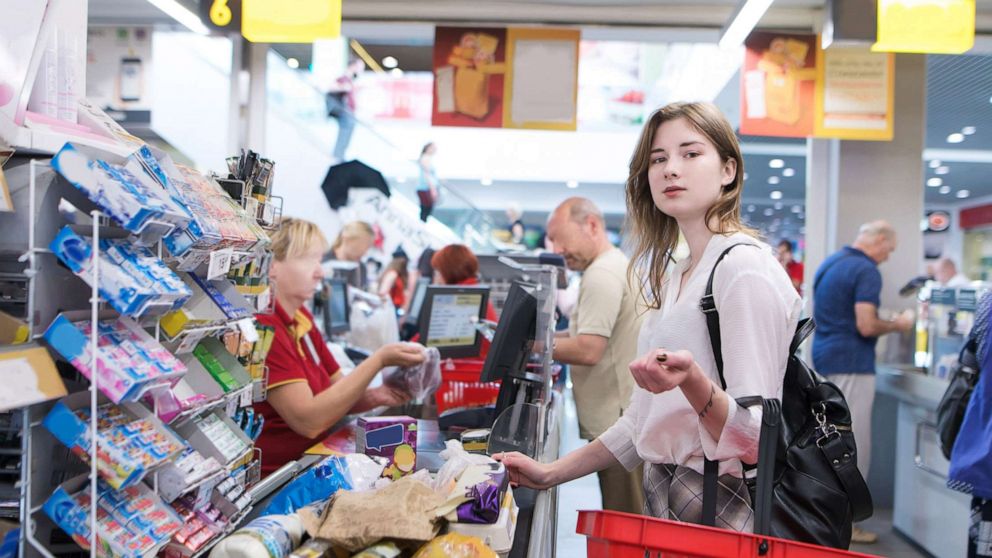 PHOTO: A shopper stands at the checkout lane while purchasing groceries at a supermarket, in a stock photo.