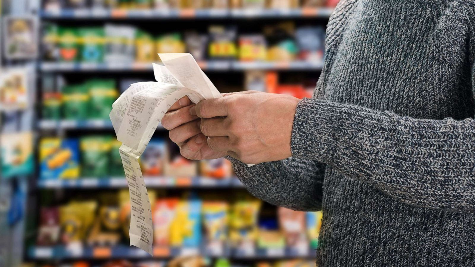 PHOTO: A shopper reviews his bill at the grocery store in a stock photo.