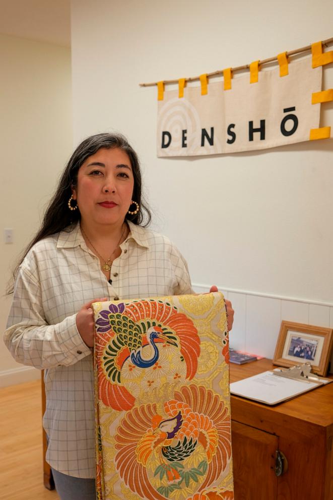 PHOTO: Caitlin Oiye Coon holds her grandmother Shizuko Kikuchi Oiye’s wedding obi at the Densho office in Seattle, Washington.