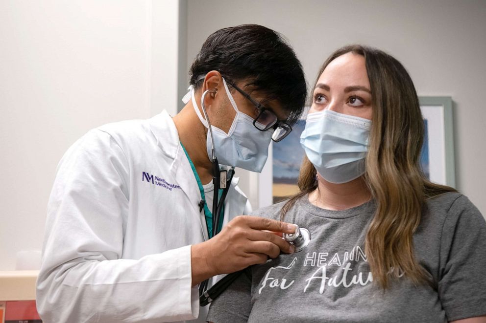 PHOTO: Dr. Ankit Bharat, chief of thoracic surgery at Northwestern Medicine, checks the lungs of Autumn Carver, who battled COVID-19.