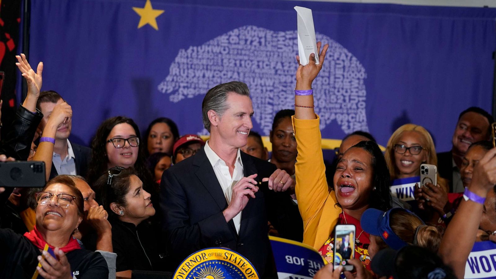 PHOTO: California Gov. Gavin Newsom signs the fast food bill surrounded by fast food workers at the SEIU Local 721 in Los Angeles on Sept. 28, 2023.