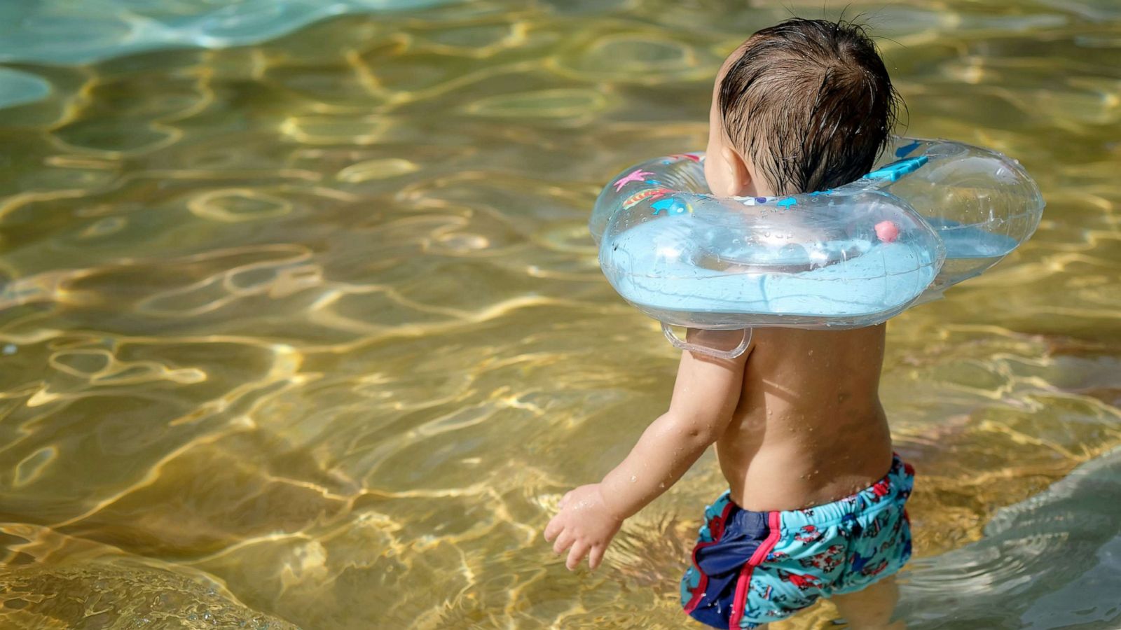 PHOTO: A small child enters a pool wearing a neck ring in an undated stock image.