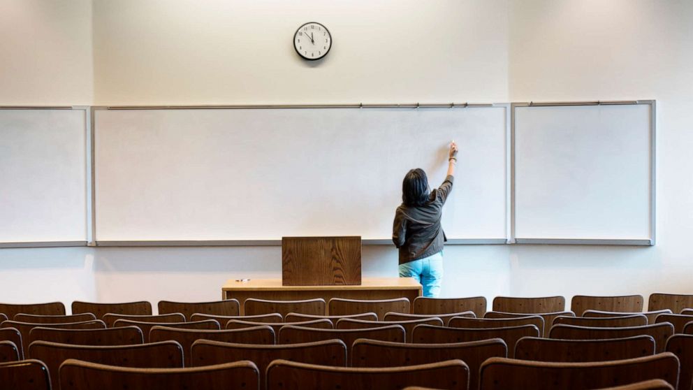 PHOTO: An undated stock photo depicts a college professor writing on a white board in front of an empty lecture hall.