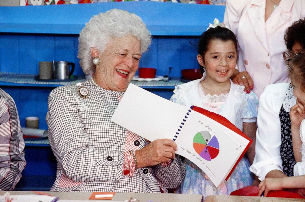 PHOTO: First Lady Barbara Bush looks at a workbook presented to her by Elizabeth Rodriquez during a visit to the YWCA to tour their literacy program facilities in Elgin, Ill., April 26, 1991.