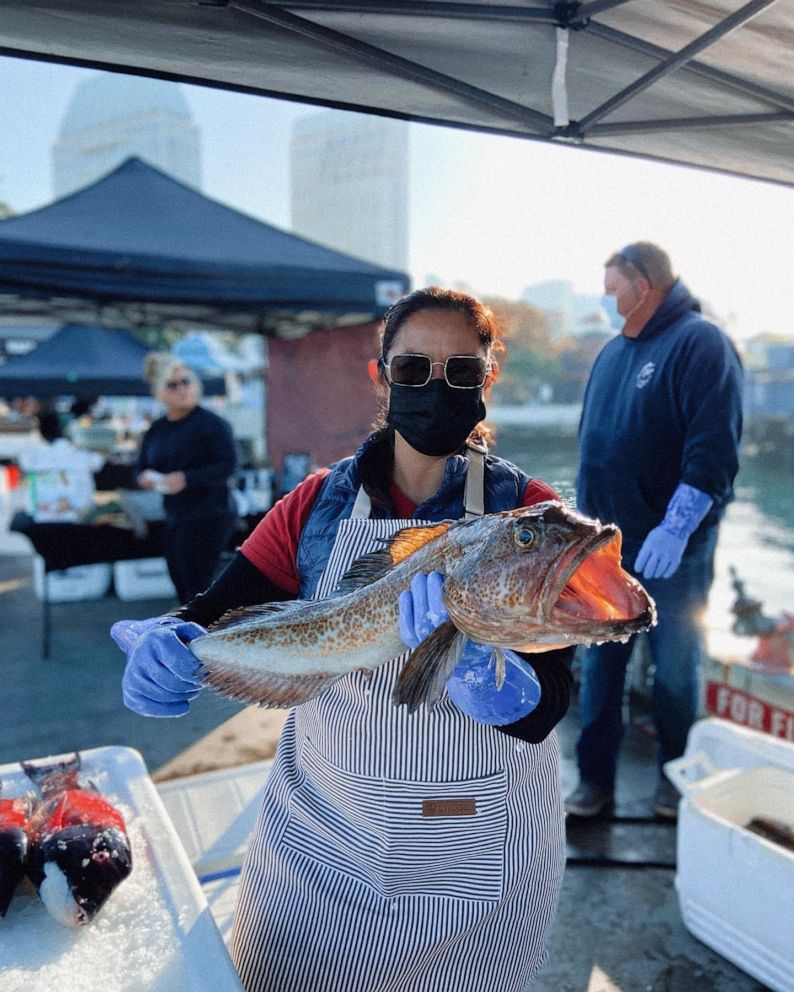 PHOTO: A sustainable seafood purveyor holds up fresh fish.