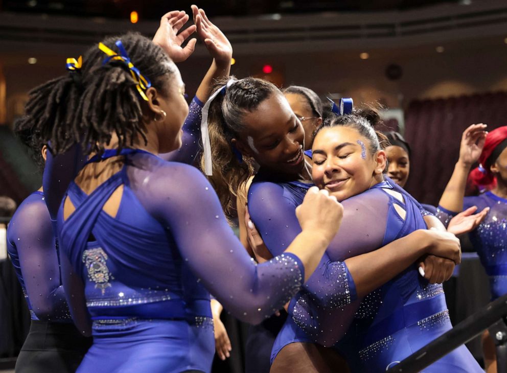 PHOTO: Fisk University's Liberty Mora, right, is embraced by teammates after performing on the floor during a Super 16 gymnastics meet, Jan. 6, 2023, in Las Vegas.
