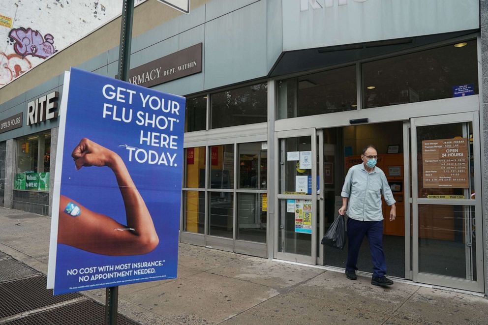 PHOTO: A man walks past a free flu shot advertisement outside of a drugstore on Aug. 19, 2020, in New York.