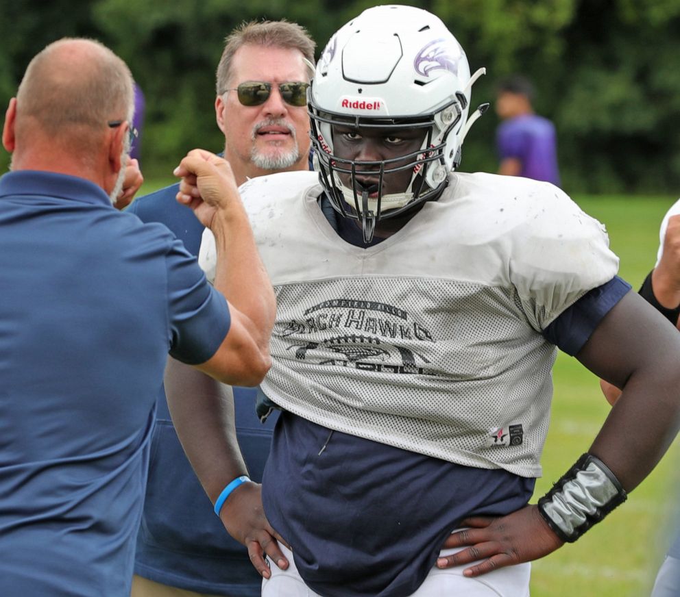 PHOTO: Al Kettinger, interpreter for Bloomfield Hills defensive lineman Devin Holmes, signs a play during practice on Wednesday, Sept. 4, 2019, at Bloomfield Hills High School.