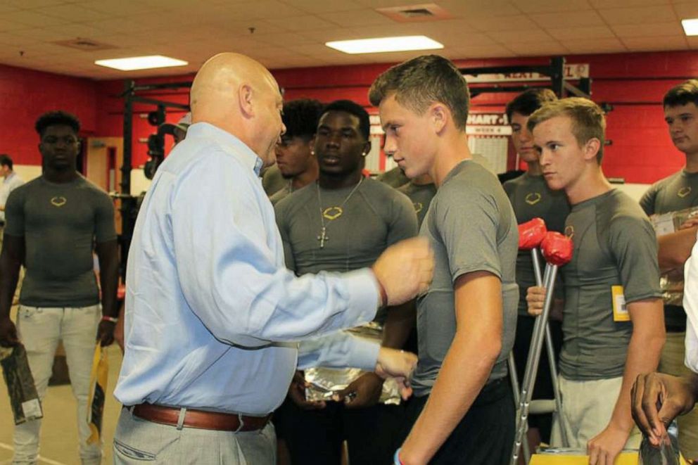 PHOTO: Brian Haugen fitting student athletes for uniforms and gear that The Taylor Haugen Foundation provides. 