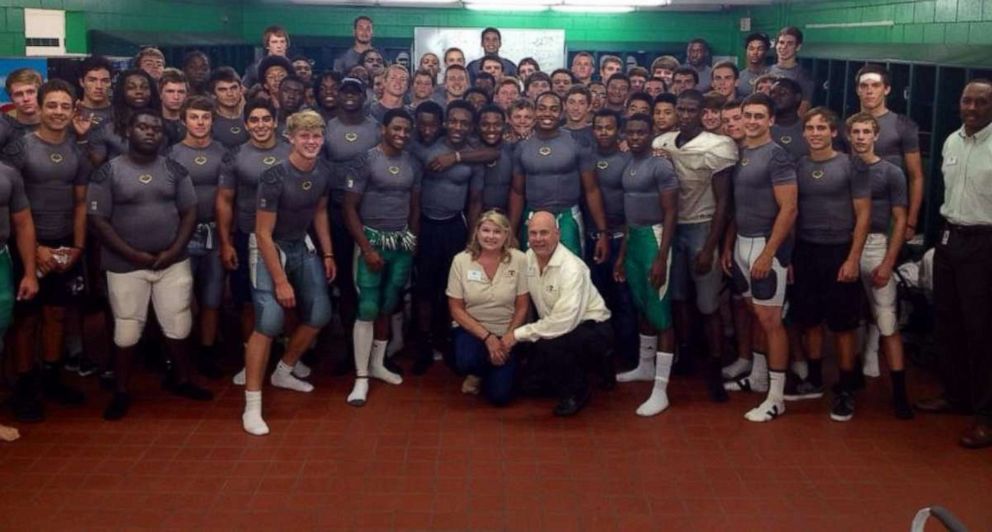 PHOTO: Kathy and Brian Haugen with a group of young football players wearing their YESS uniforms.