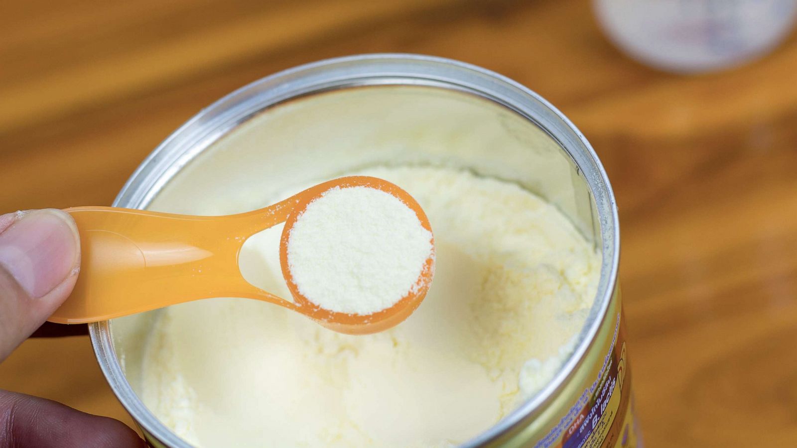 PHOTO: Powder milk and blue spoon on light background close-up. Milk powder for baby in measuring spoon on can in an undated stock photo.