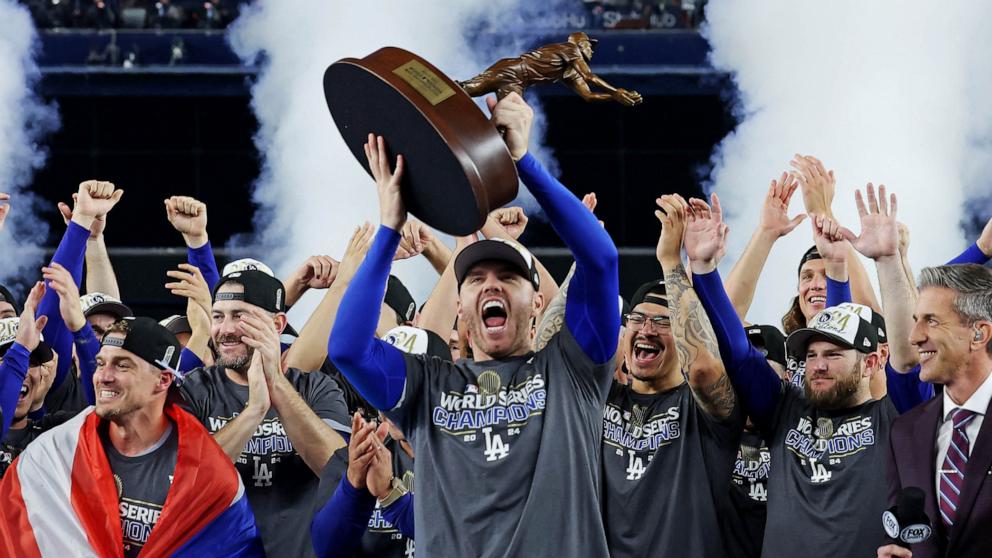 PHOTO: Los Angeles Dodgers' Freddie Freeman celebrates with the MVP trophy after their win against the New York Yankees in Game 5 to win the baseball World Series, Oct. 31, 2024, in New York. 