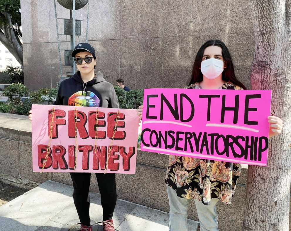 PHOTO: Two Free Britney supporters hold up signs calling to end the pop star's conservatorship in front of Stanley Mosk Courthouse in Los Angeles.