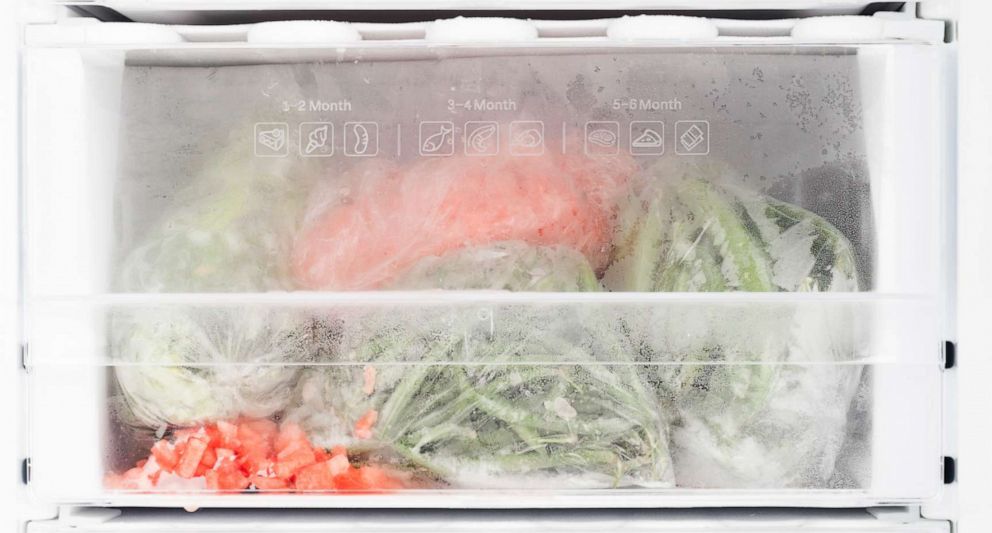 PHOTO: Freezer with open door and frozen food