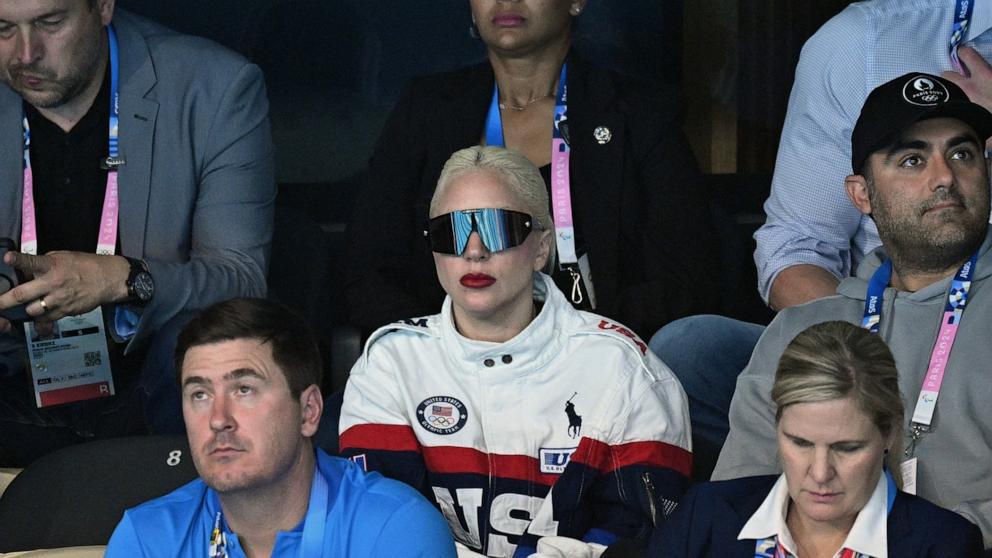 PHOTO: US singer and actress Lady Gaga (C) attends the swimming event during the Paris 2024 Olympic Games at the Paris La Defense Arena in Nanterre, west of Paris, on July 28, 2024.