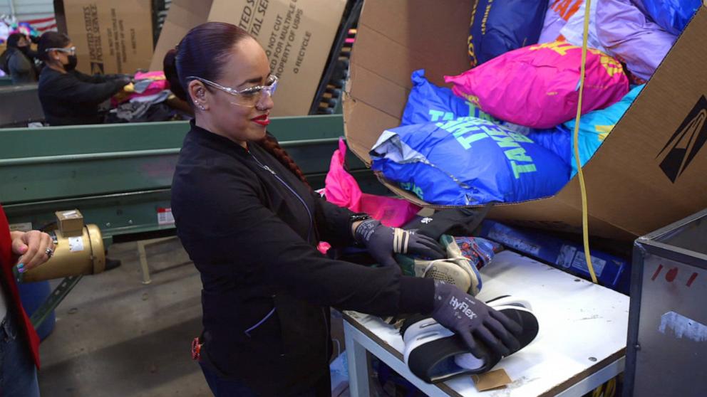 PHOTO: ABC News Chief Meteorologist Ginger Zee examines how donated clothes are processed.