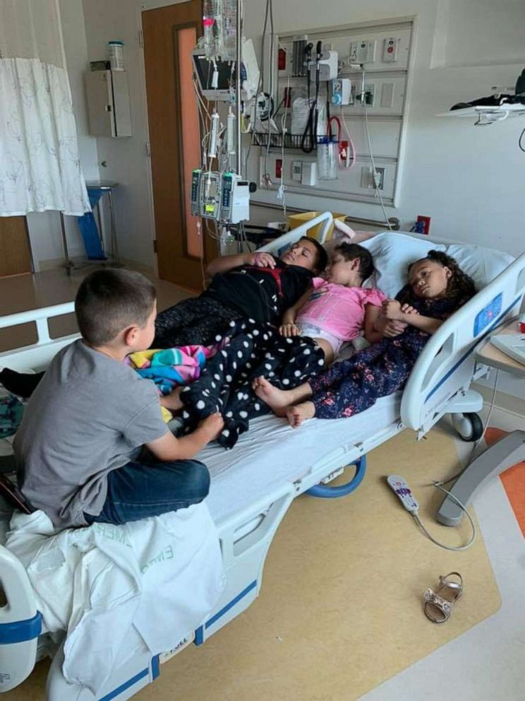 PHOTO: Zoe Figueroa, 8, is seen is seen laying in a hospital bed with her brothers Zach, 11 and Zayden, 7 and sister Zandrea, 5.