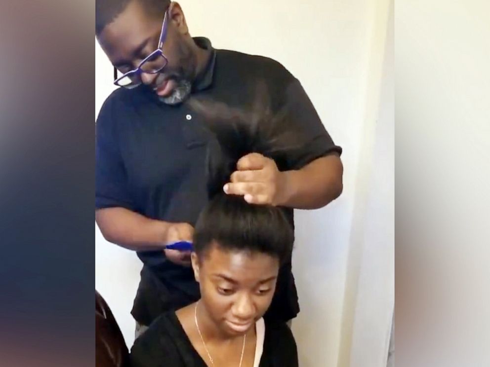PHOTO: Lufrey Jonas does his 14-year-old daughter Arielle's hair in Baltimore.