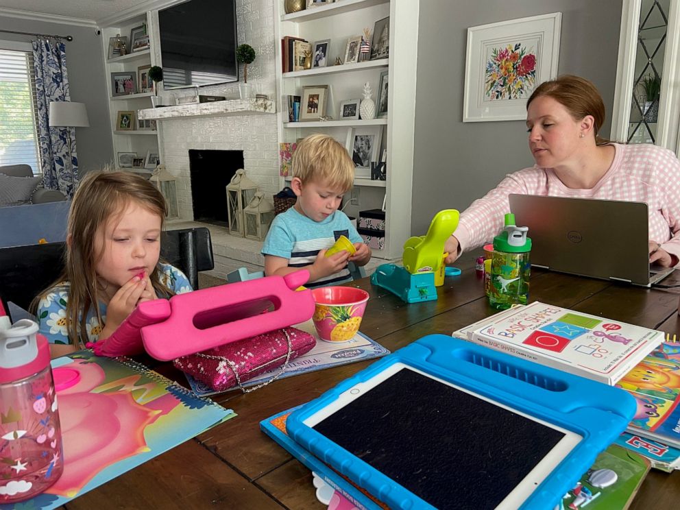 PHOTO: Kate Dando Doran, of Colorado, works at her dining table alongside her two children, ages 5 and 3.