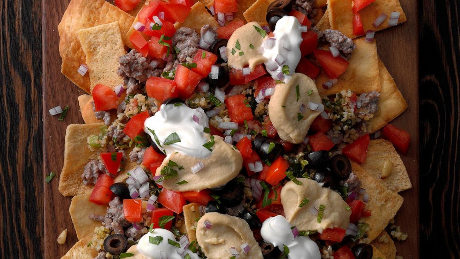 PHOTO: A Middle Eastern flair to classic Nachos, featuring pita chips, hummus, and sliced olives.