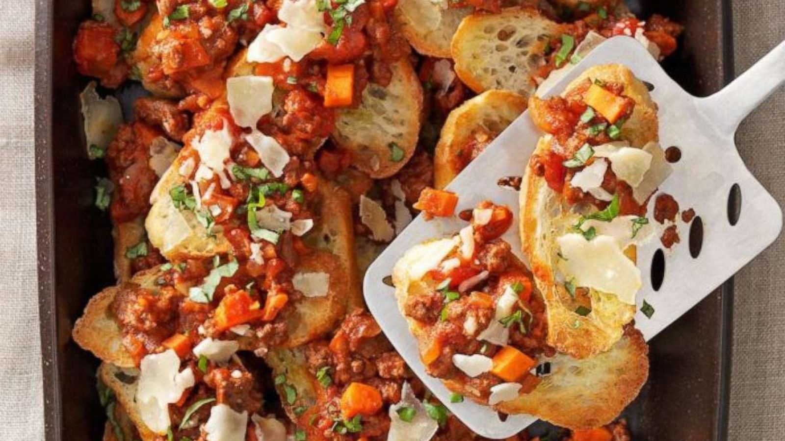 PHOTO: Bread crisps topped with meat sauce and basil.