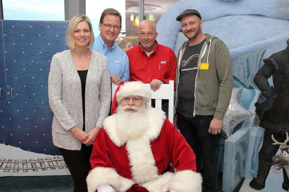 PHOTO: Mark Miller, center, in red, poses with Santa Claus and other parents and officials at Children’s of Alabama.