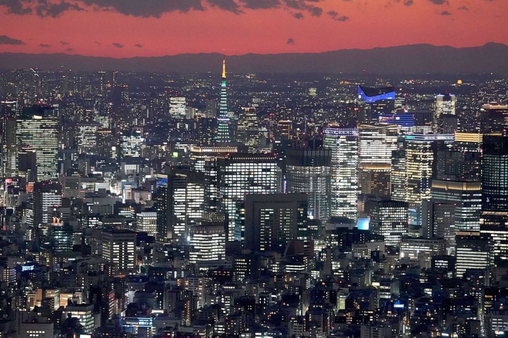PHOTO: Tokyo Tower, middle, and buildings are lit up in Tokyo, Japan, Dec. 25, 2020. 