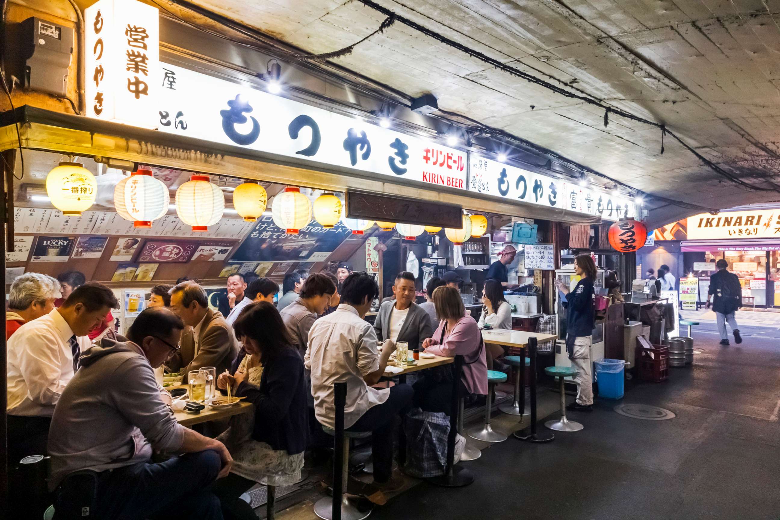 PHOTO: Diners eat at a traditional open air Yakitori Restaurant in Tokyo, Japan.