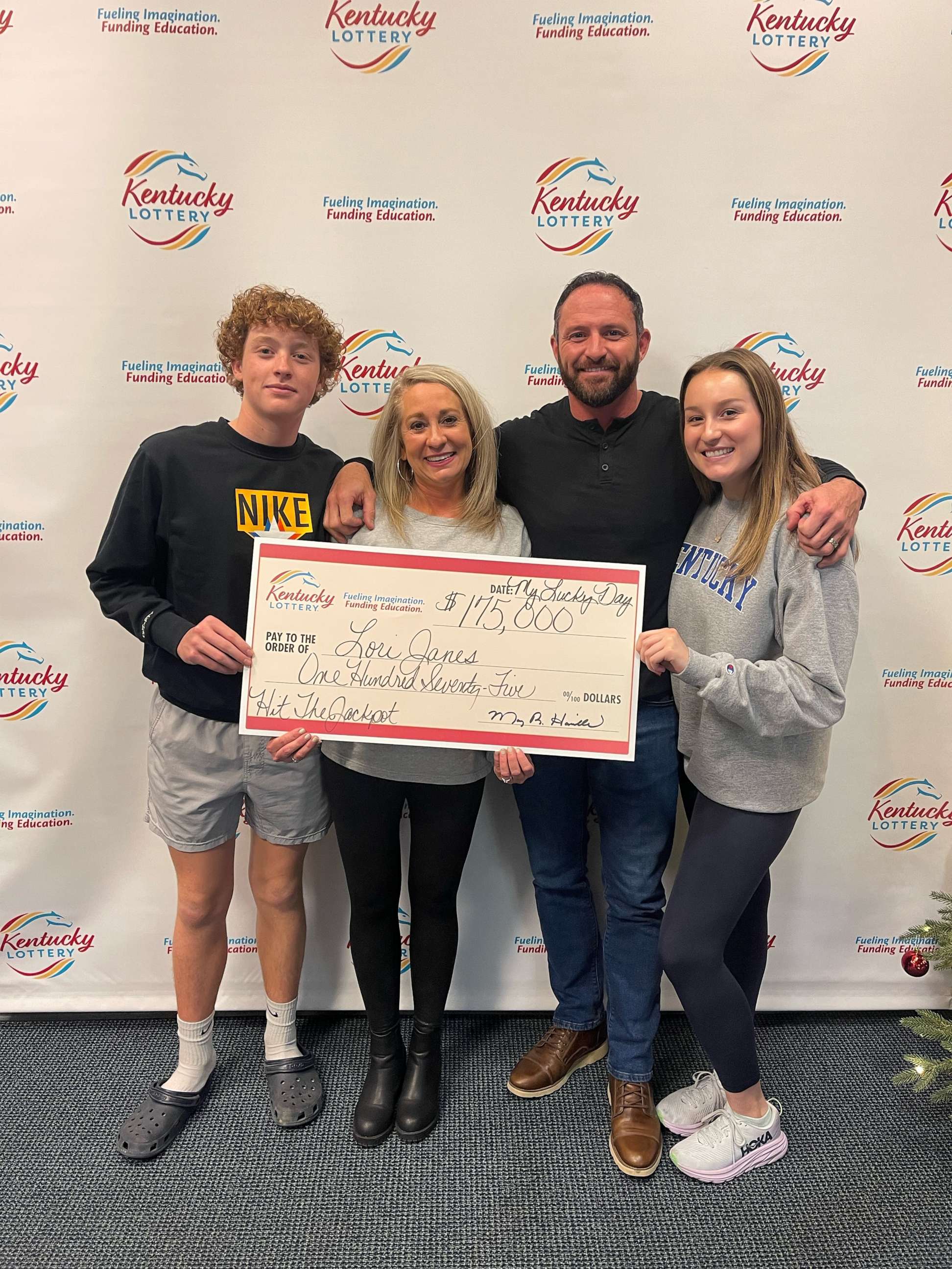 PHOTO: Lori Janes, of Louisville, Kentucky, poses with her family and her winning lottery check.