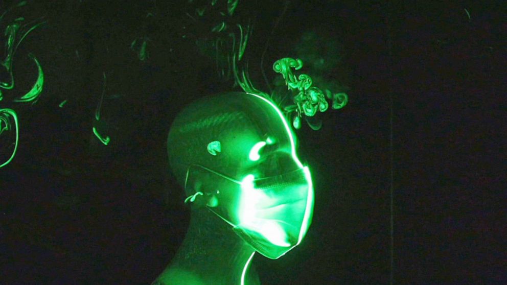 PHOTO: A masked mannequin head is seen in a  screen grab, of a demonstration showing that there are significantly fewer particles escaping after researchers pushed down on the internal nose clip in the mask. 